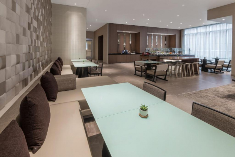 The accessible breakfast area has smooth floor with a service counter, assorted tables, some fixed seating and moveable chairs.