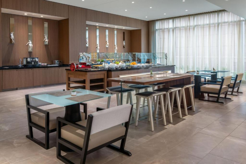 The spacious breakfast area has an island counter and assorted high and low tables and chairs or stools.