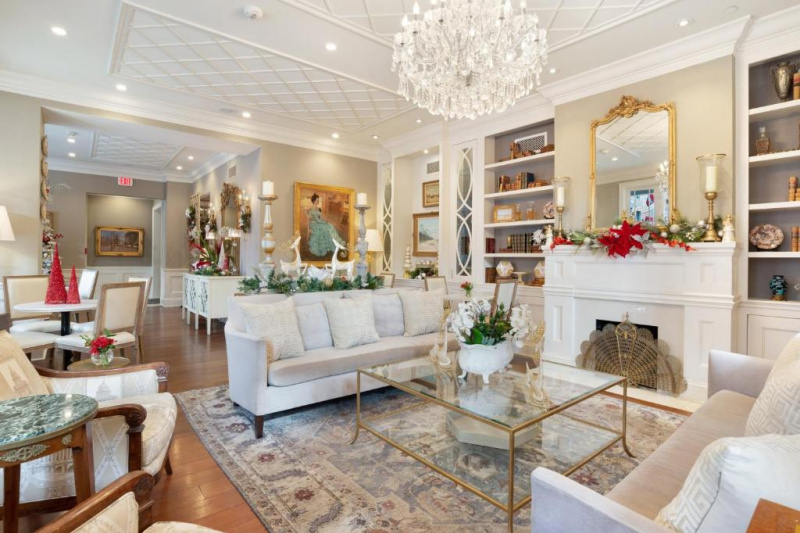 The hotel lobby has a comfortable seating area with sofas, table and chairs a fireplace and an elegant chandelier.