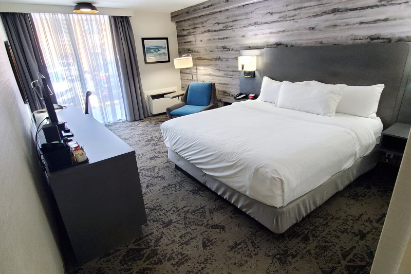 The traditional one king room has a king-sized bed, an armchair, lamps, a telephone, a TV, a desk, a chair and floor-to-ceiling windows.