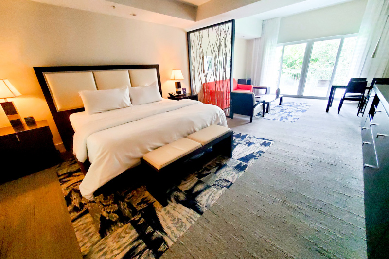 The king studio suite has a king-sized bed, a seating area with sofa and chairs and a dining area.