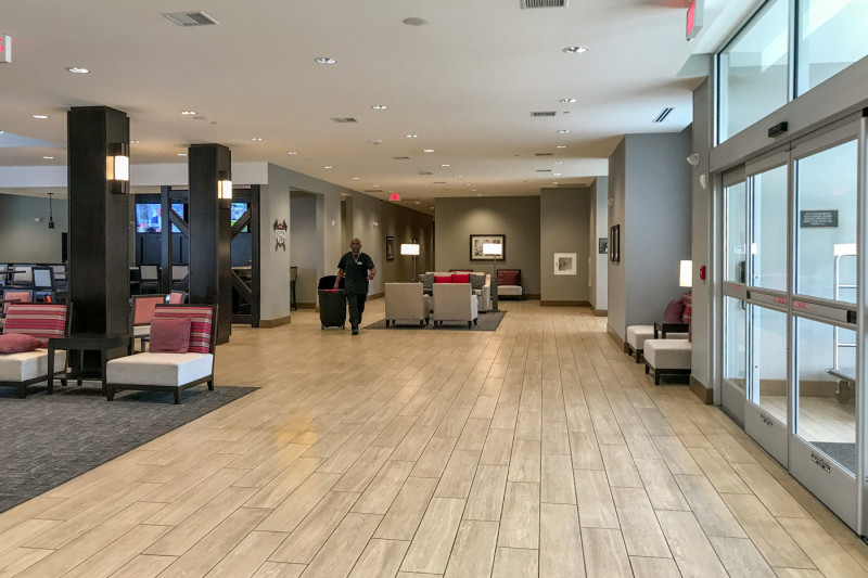 The well-lit spacious hotel lobby has low padded seats and artwork on the walls.