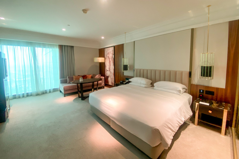 The spacious accessible superior king room 1 has an extra-large double bed, nightstands, a telephone and hanging lamps. There is a seating area with a low-back sofa, table and floor lamp and plenty of space to move around the room.