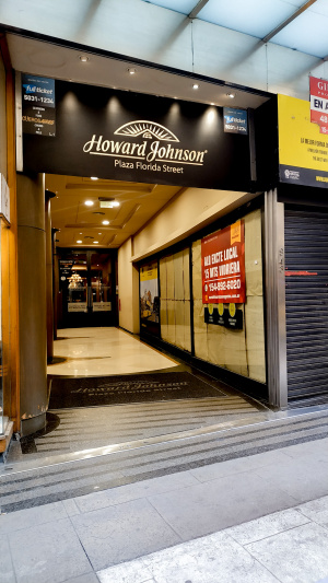 The accessible entrance to the hotel is well-lit with shops on either side.