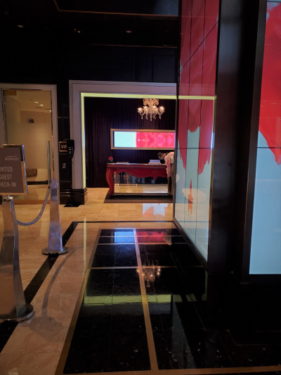 step-free entrance to the VIP reception area. There is a wall of video screens on one side of the entrance.