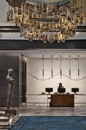 The lobby area has the reception desks which have lowered sections. There is a large L-shaped sofa with a coffee table. There is also another sofa and coffee table just out of shot.