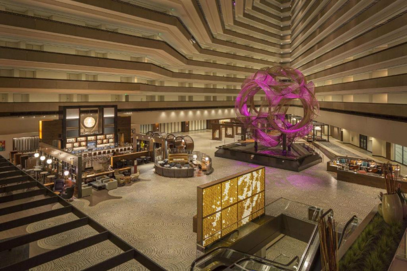 The spacious atrium lobby has a bar, several seating areas and a central art installation with ramped access.