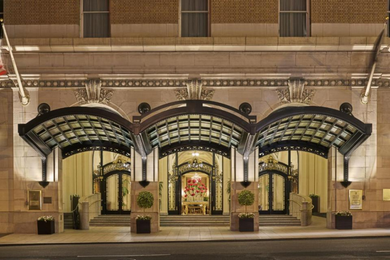 The huge entrance to the hotel is from the sidewalk. There are 3 large, covered doorways, with steps leading up to them. There is a ramp to one side of the stairs.