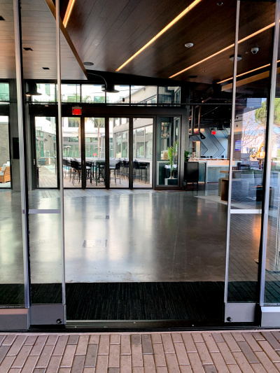 The entrance to the hotel is through automatic, sliding doors. The lobby is spacious and leads to an outdoor seating area