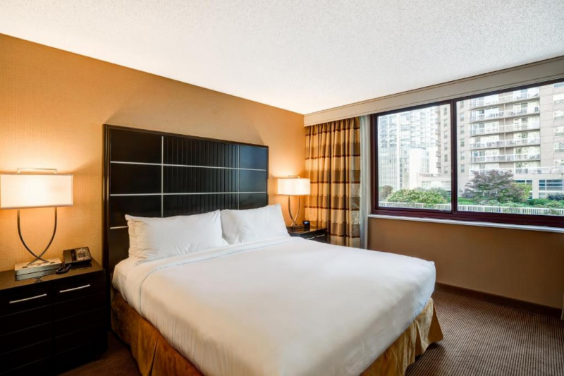 This lower-floor suite has a king-sized bed with two large nightstands with lamps. There is a push-button telephone and an alarm clock.