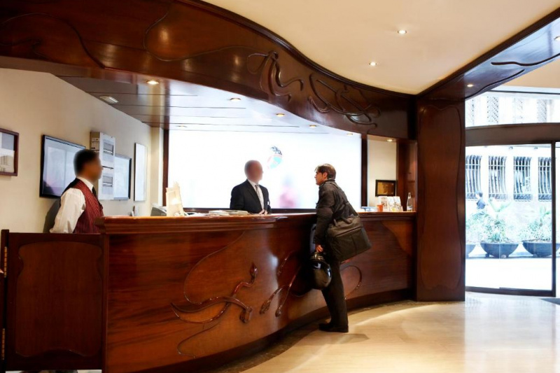 The long, slightly curved wooden reception desk is all standard height.