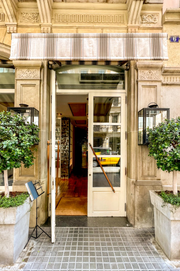 The hotel entrance has step-free access through double doors with potted trees on either side.