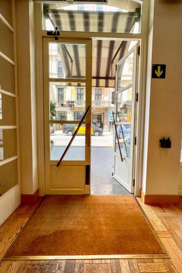 The hotel entrance provides step-free access through double doors onto a coir doormat.