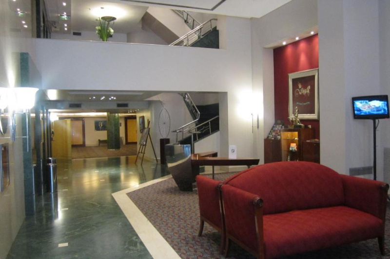 The hotel lobby has a comfortable seating area with sofas and a TV. There are stairs leading the the first floor.
