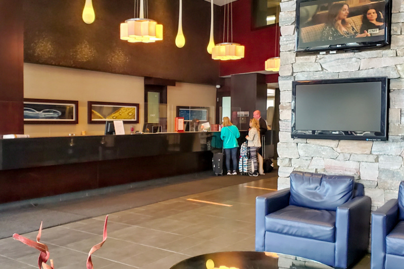 The spacious check-in area has a long standard height reception desk. There is also a seating area with comfortable armchairs and a wall-mounted TV.