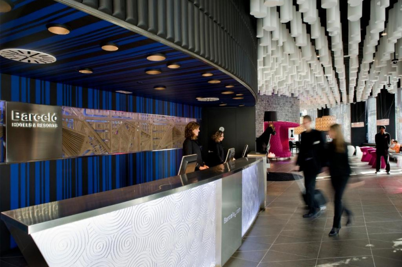 The spacious reception area has a standard height check-in desk. There is a large seating area with assorted tables and chairs.