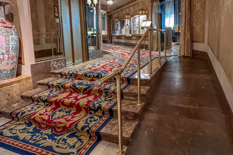 There are 4 stairs with a handrail. The steps lead to a corridor.