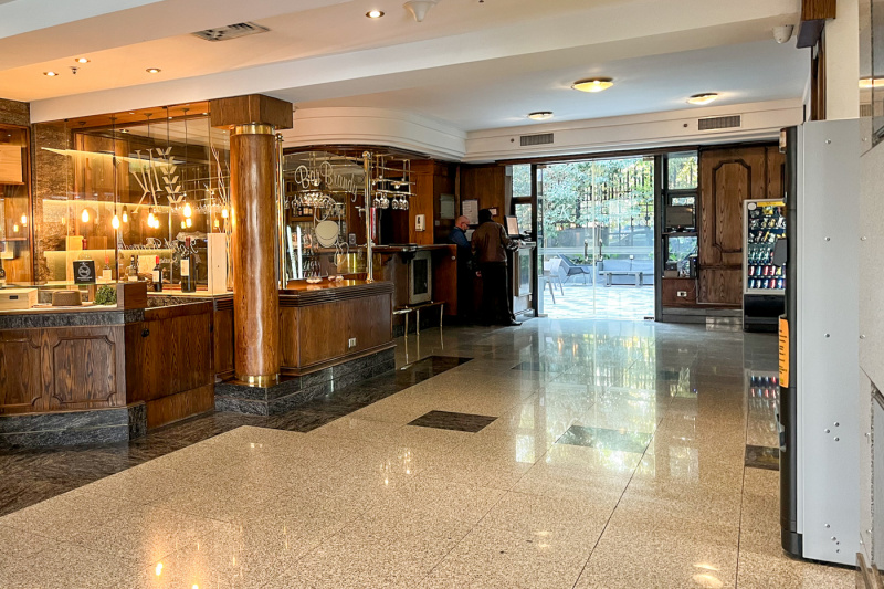 The wood-paneled bar has a standard height countertop. There is step-free access to the outside seating area through 2 glass doors.
