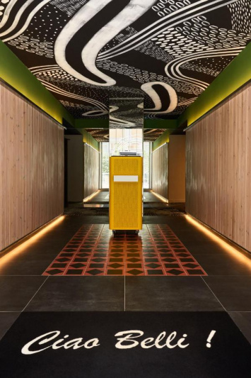 The entrance is a long, tiled corridor. There is a step halfway along it, leading to another area.