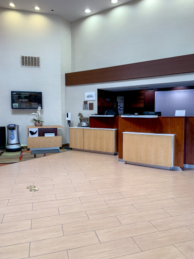 The spacious reception area has two high check-in desks. One has a low shelf and the other has a lowered counter area and shelf that are wheelchair-accessible. There is also a wall-mounted TV advertising events.