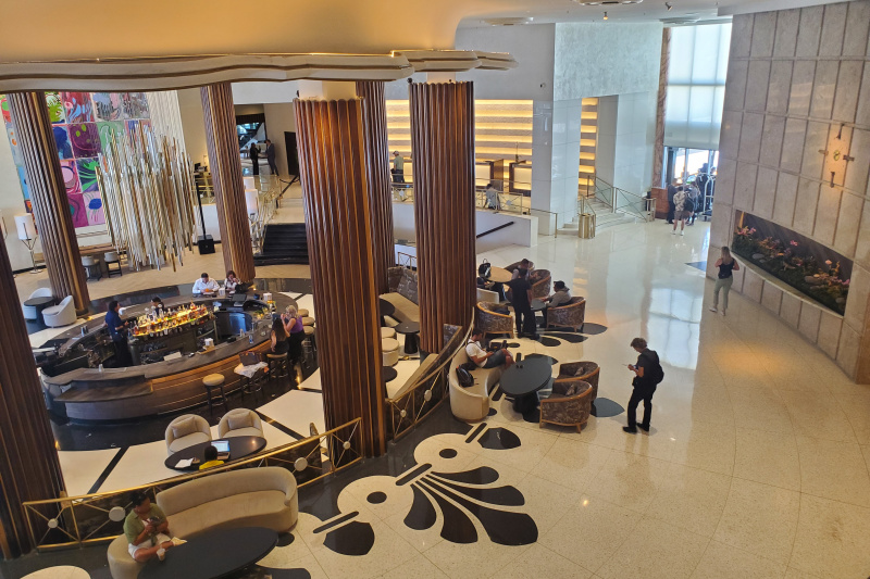 The spacious hotel lobby features seating areas and a large, circular, central bar on a lower level. The check-in desks are near the hotel entrance up a flight of steps.There is also a ramp with handrails.