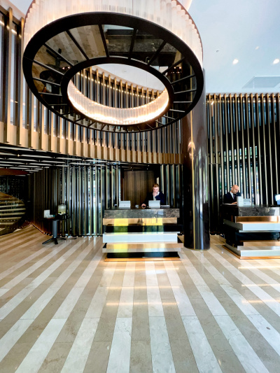 There are 2 high reception desks in a large, step-free area. One desk has a lowered counter.