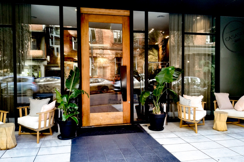 The step-free entrance to the hotel is from the sidewalk. Access is through a large single wooden and glass door.
