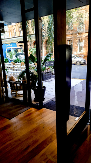 The hotel exit from the lobby to the sidewalk is through a large single door. There is a doormat outside.