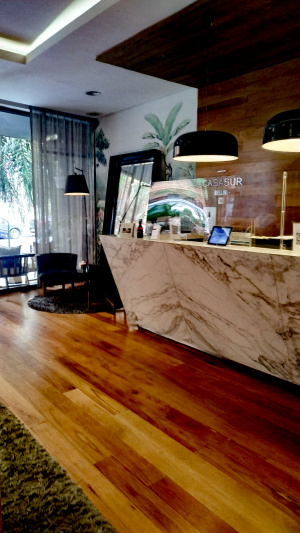 The high reception desk is in a step-free area. To the left of the reception desk there are 2 comfortable chairs.