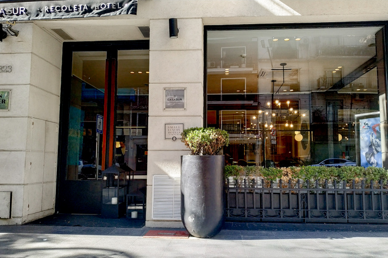 The entrance to the hotel is from the sidewalk through a tall glass door.