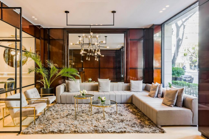 The seating area has an L-shaped corner sofa. There are 2 coffee tables and 2 armchairs with plenty of floor space around the seating.