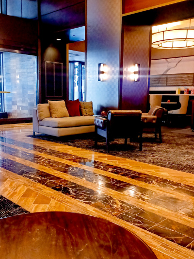 The spacious lobby has assorted seating areas. There are sofas, coffee tables, and movable chairs.