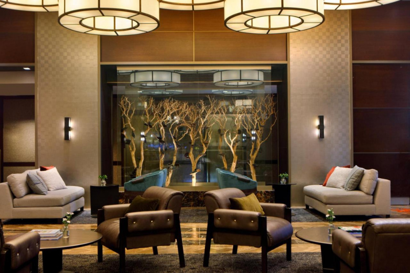 The spacious seating area has elegant sofas, heavy movable chairs, and coffee tables. There is plenty of floor space between the seating.
