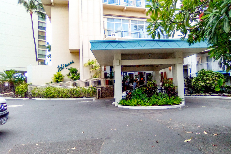 The hotel entrance has a large drive-up area. There is a long ramp with handrails to one side. The ramp is on an upward incline.