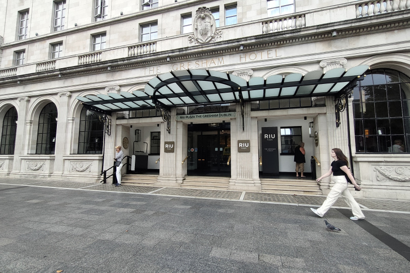The hotel entrance is from the sidewalk. There are 3 steps with handrails leading up to the sliding doors. One set of steps has a wheelchair lift.