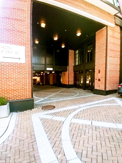 Access to the hotel entrance is from a large, brick-paved driveway.