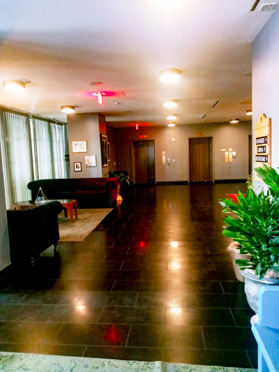 The spacious, step-free area has 2 sofas, a table, and 2 elevators at the far end.