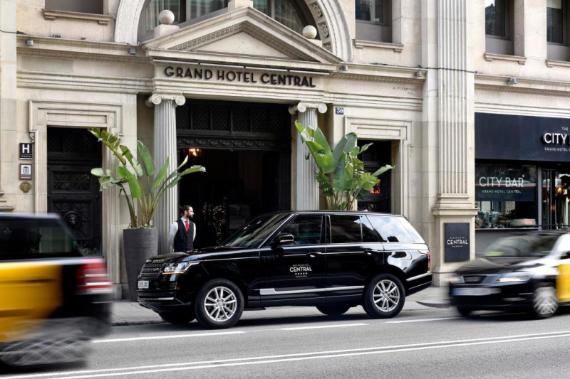 View of the hotel entrance from the street. There is a dropped kerb drop-off area outside the hotel.