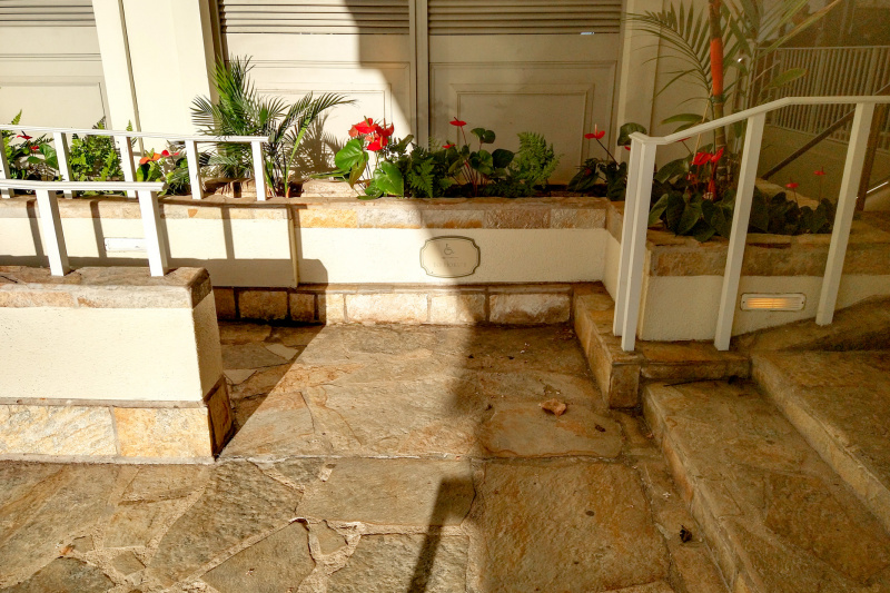 There is a wheelchair-accessible sign at the foot of a shallow ramp with handrails.