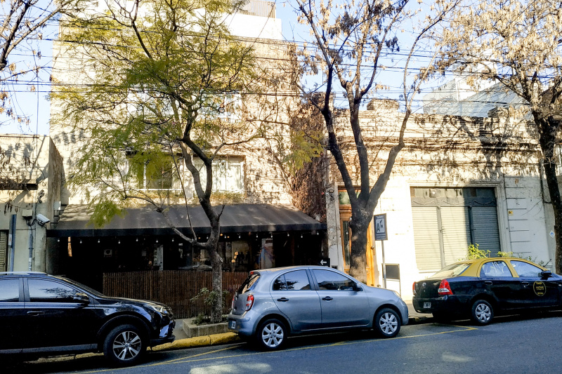 An exterior view of the hotel from the sidewalk. There is a drop-off zone outside the hotel.