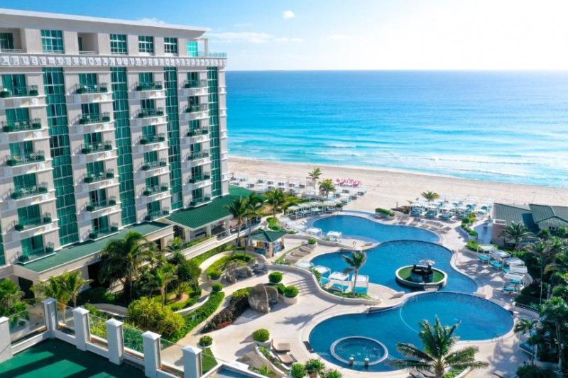 Aerial view of the hotel with outdoor pools and beach.