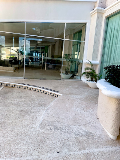 There is a short ramp leading from the roadway up to double, glass doors.