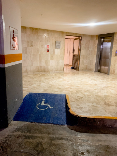 In the car park, there is a clearly marked wheelchair access ramp leading to an elevator.