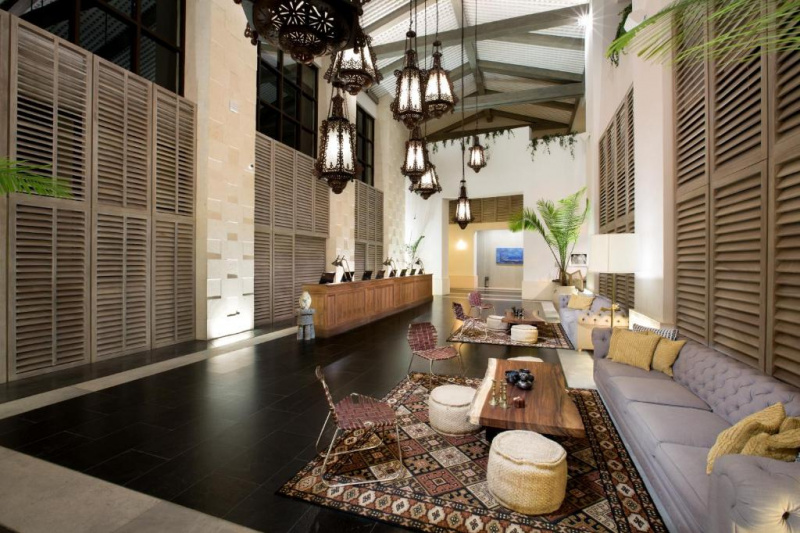 The spacious reception area has a high check-in counter. There are sofas along one wall, with coffee tables and movable chairs.