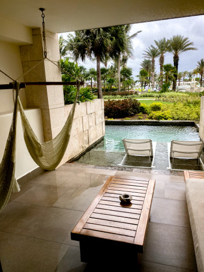 The outdoor pool has steps leading into the water with sun loungers. There are no grab bars.