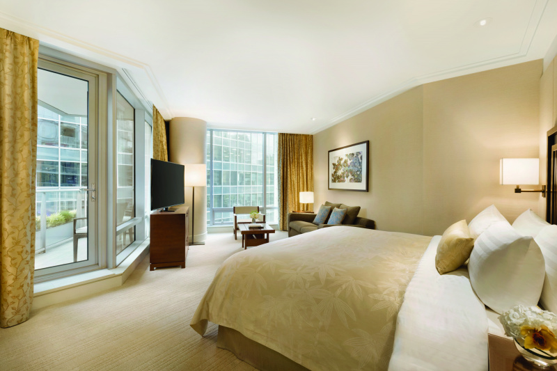 Spacious bedroom, carpeted floor and balcony with a step