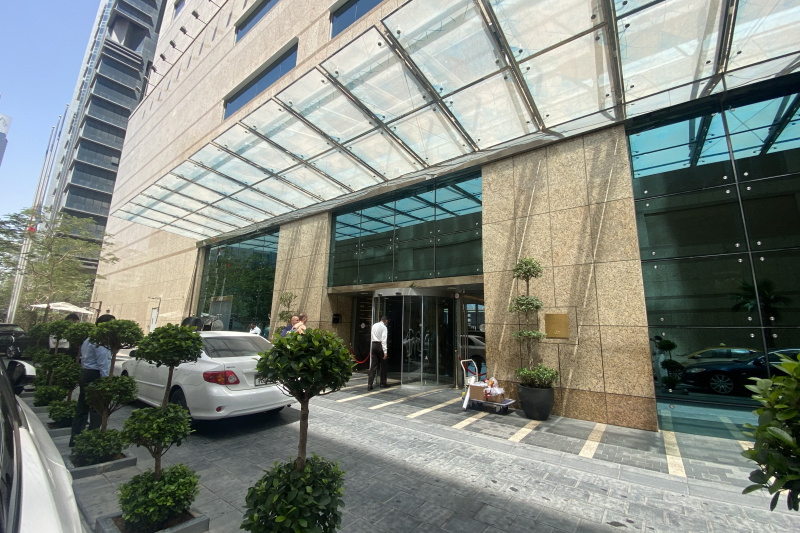 The hotel entrance is from a drop-off area. There is a revolving door with single glass doors on either side.