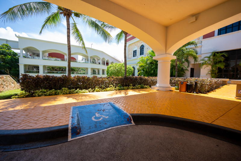 There is a dropped curb and clearly marked shallow ramp leading from the covered drop-off zone to the ramp giving access to the hotel entrance.