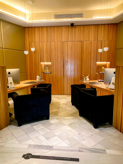 There are 2 reception desks opposite each other. Each desk has 2 heavy chairs in front of them.
