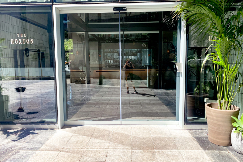 Access to the hotel lobby from the paved sidewalk is through 2 sliding glass doors.